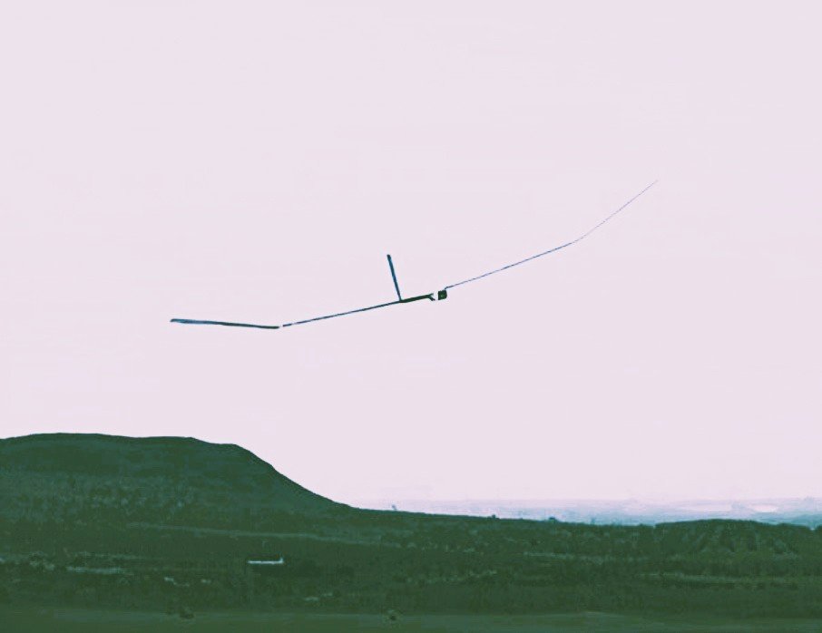 Drone flying in the sky with hills in the background.